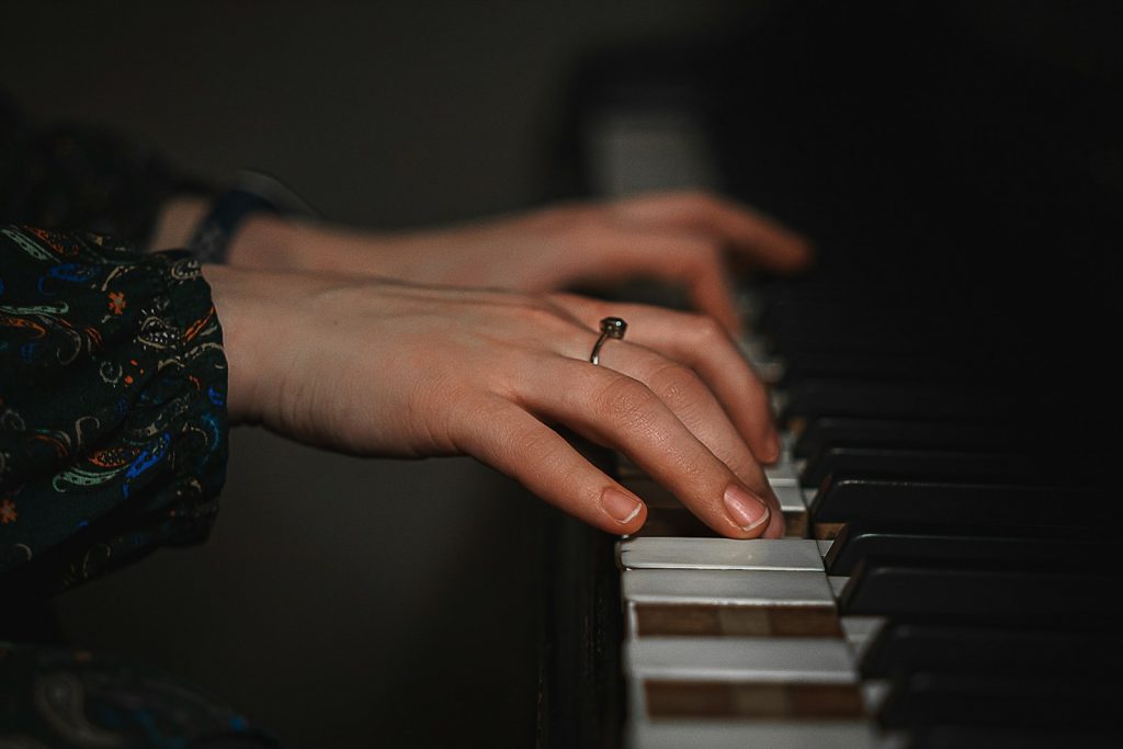 Frauenhände spielen Klavier beim Klavierunterricht