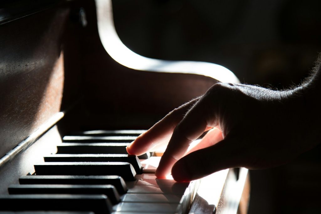 Die Hand eines Erwachsenen beim Klavierunterricht